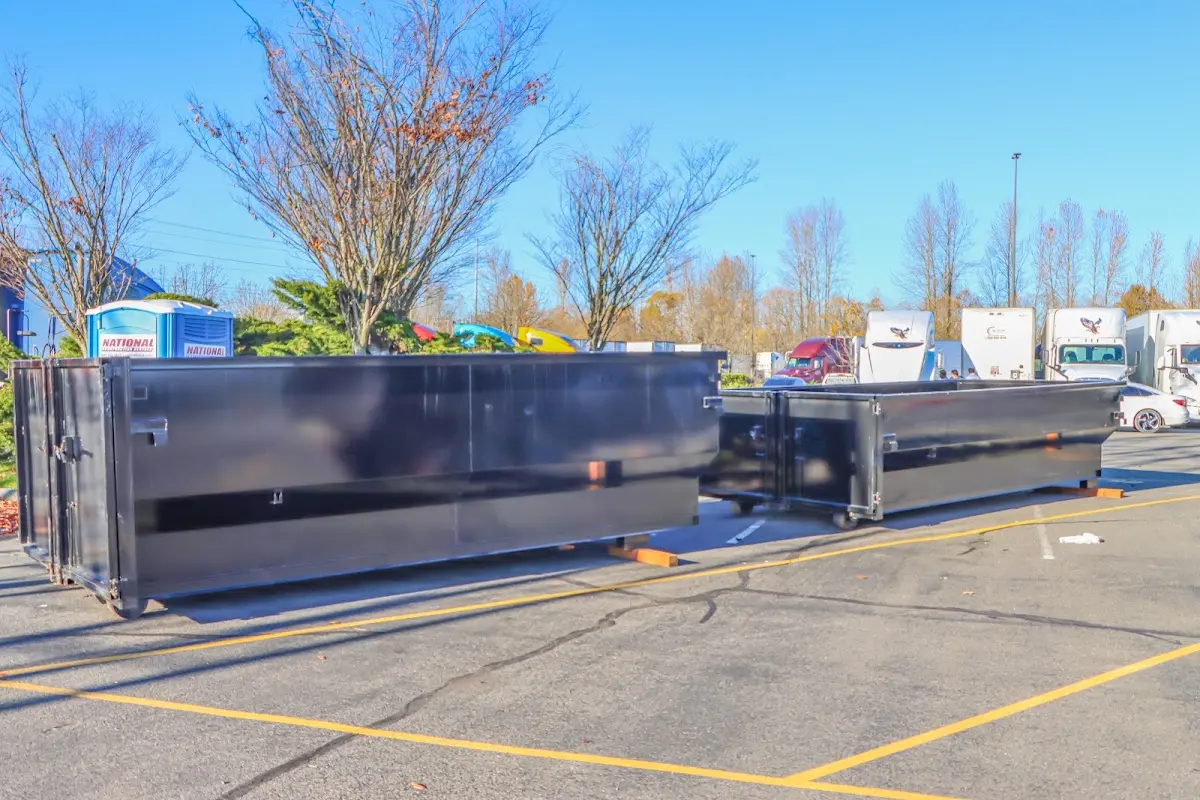 Professional dumpster rental service with roll-off container on residential driveway in Hallsville